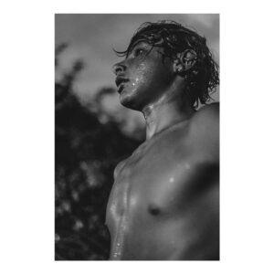 Foto che ritrae un giovane surfista sudato in bianco e nero
